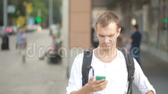 男人在街中央打电话年轻人在智能手机上发短信视频的预览图