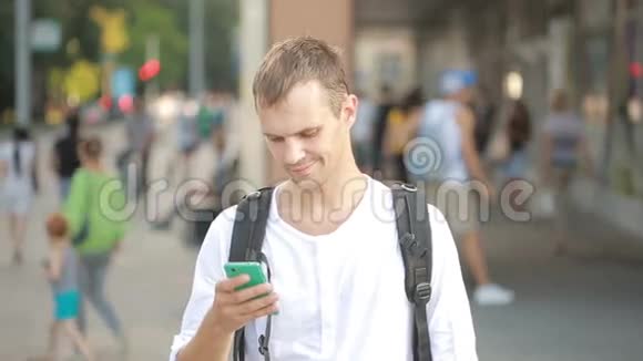 男人在街中央打电话年轻人在智能手机上发短信视频的预览图