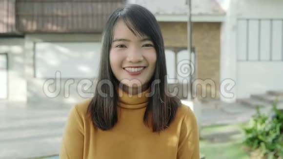 一位年轻的亚洲妇女晚上在市中心的大街上旅行时对着镜头微笑着视频的预览图