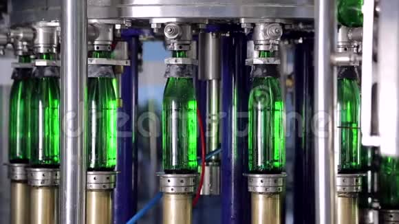 线的制水绿色玻璃瓶沿着生产线自动移动并装满水视频的预览图