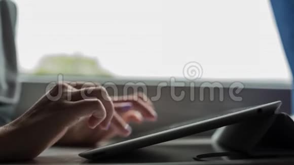 年轻女孩打字和使用平板电脑用美甲特写双手视频的预览图