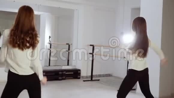 两个年轻女孩正在舞蹈室跳舞晚上的舞蹈排练视频的预览图