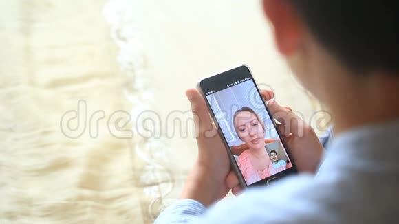 少年男孩在智能手机上和女人视频聊天视频的预览图