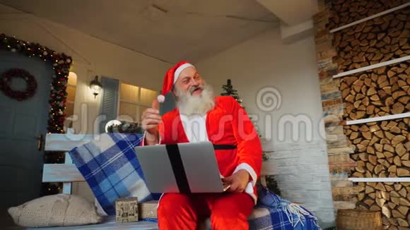 有趣的圣诞老人竖起大拇指用笔记本电脑工作视频的预览图
