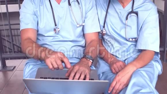 医生坐在地上时使用笔记本电脑视频的预览图