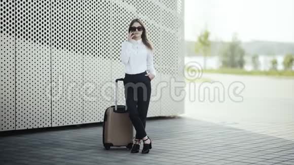 女士带着行李在机场打电话视频的预览图