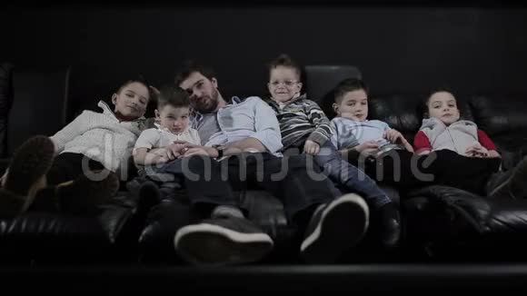 有小孩的男人躺在电影院的沙发上视频的预览图