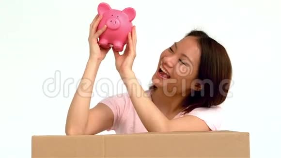 快乐的亚洲女人摇动储蓄罐视频的预览图
