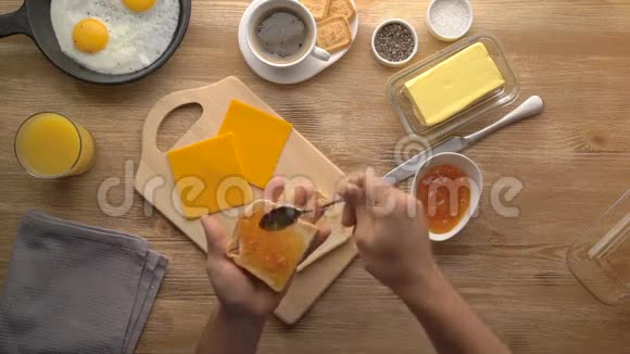 男性手准备带果酱的早餐吐司视频的预览图