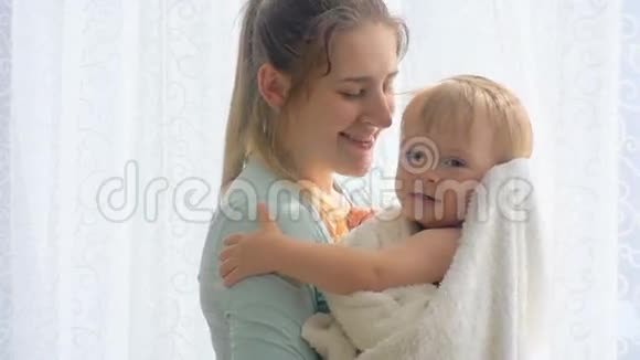 美丽的年轻女子拥抱亲吻她的小儿子的肖像视频的预览图