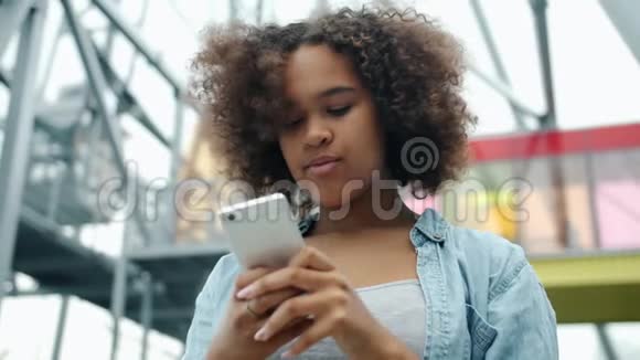 非洲裔美国青少年正在户外街头使用现代智能手机视频的预览图