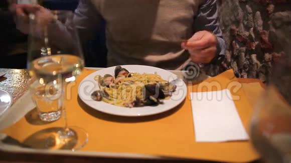 在餐厅吃意大利面和海鲜的男人视频的预览图