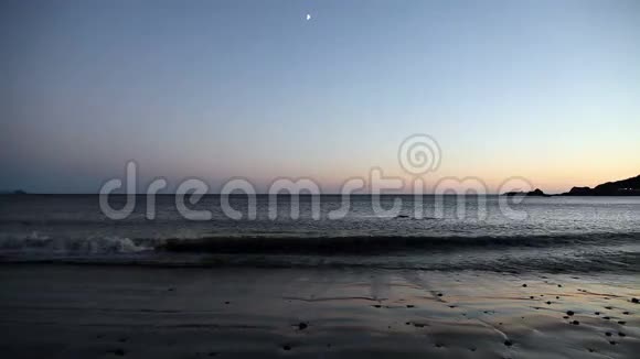 与月亮在黄昏的沙滩上视频的预览图