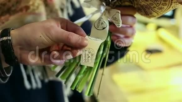 男性手拿着剪刀正在花束上剪一条装饰丝带视频的预览图