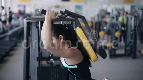 年轻迷人的亚洲女性在健身房由滑块小车右向左拍摄视频的预览图