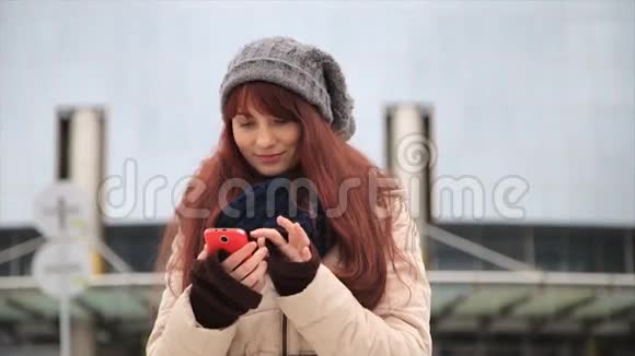 年轻的时髦女孩带着智能手机在街上对着镜头微笑视频的预览图