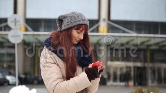 年轻的时髦女孩带着智能手机在街上对着镜头微笑视频的预览图