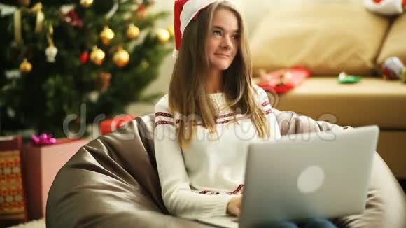 圣诞前夜一个漂亮的女孩在笔记本电脑上给圣诞老人写信视频的预览图