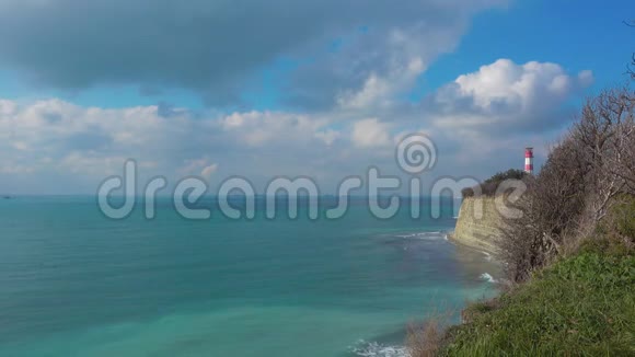 灯塔和海洋海岸悬崖在美丽的日子船在远处视频的预览图