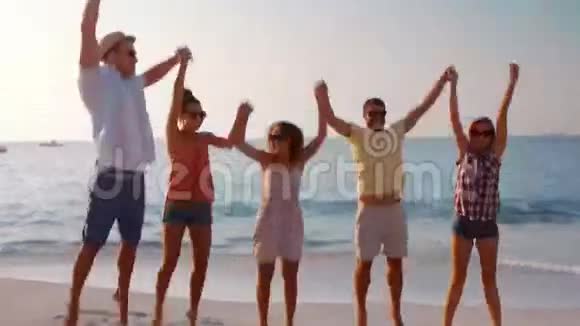 一群快乐的朋友在海滩上欢呼视频的预览图
