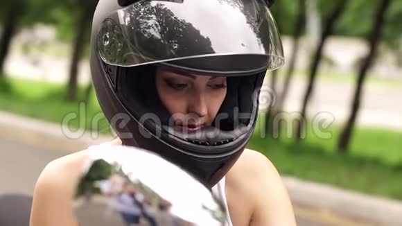 骑摩托车戴头盔的年轻女孩的肖像视频的预览图
