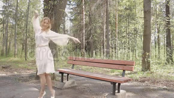 美丽快乐的女人在公园跳舞视频的预览图