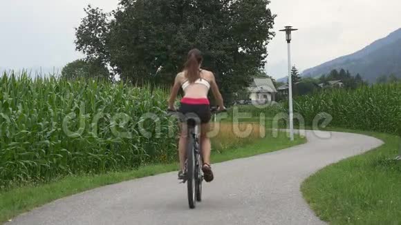小女孩骑自行车在农村公路上视频的预览图
