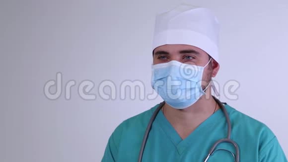 一位戴着面具看镜头的医生的特写肖像视频的预览图