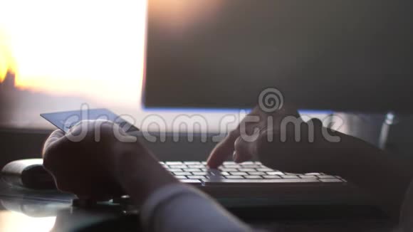 女人在日落时用电脑用信用卡在线购买快关门3840x2160视频的预览图
