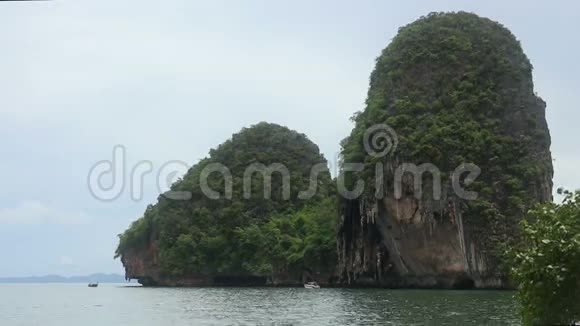 海滩附近和游艇附近有岩石的岛屿视频的预览图