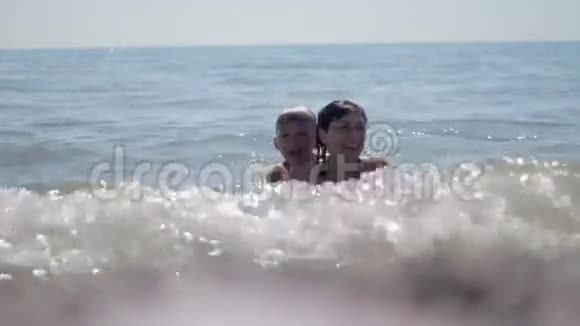 年轻的母亲和小儿子在海上游泳视频的预览图