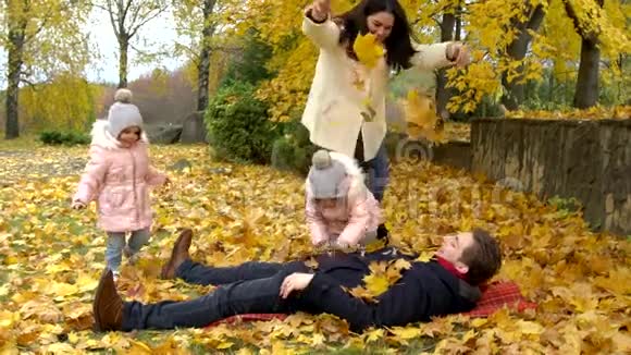 秋天公园的幸福家庭妈妈爸爸和两个小女孩视频的预览图