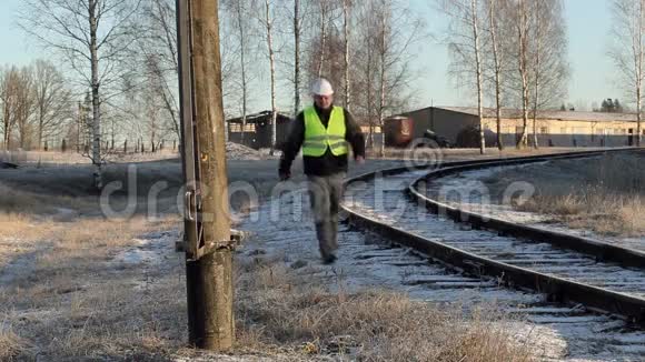 冬季铁路附近高压电杆使用平板电脑的工人视频的预览图