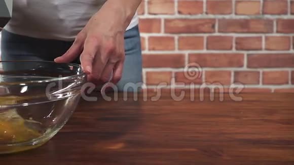 女人用搅拌器将鸡蛋搅拌成玻璃碗超级慢动作高清视频视频的预览图