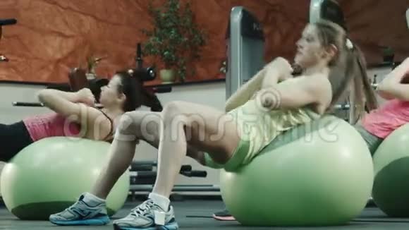 在健身馆锻炼健身球的妇女视频的预览图