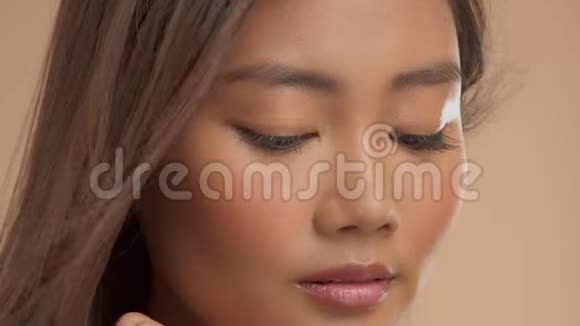 泰裔亚洲模特米色背景自然化妆视频的预览图