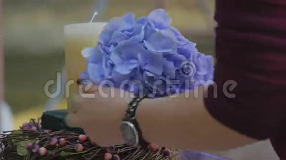 女人在婚礼上用鲜花装饰蜡烛视频的预览图