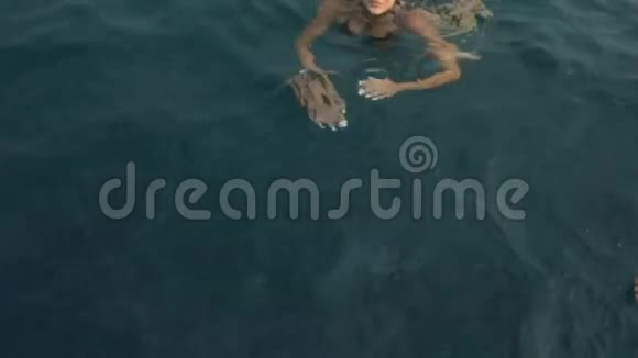 穿比基尼的迷人的年轻湿漉漉的女人爬上出海的船视频的预览图