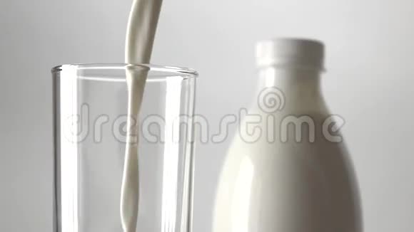 将牛奶倒入玻璃超慢动作近距离拍摄灰色背景视频的预览图