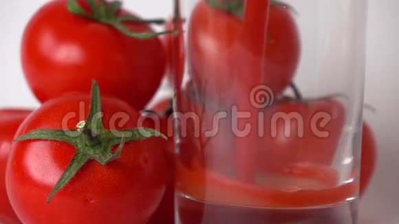 一些红西红柿和西红柿汁倒入玻璃杯中超级慢动作视频的预览图