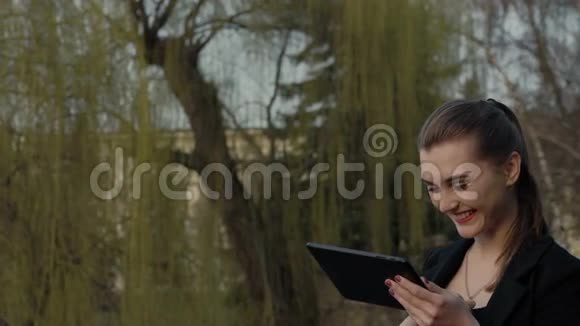 商务女士在公园里享受平板电脑慢慢地视频的预览图