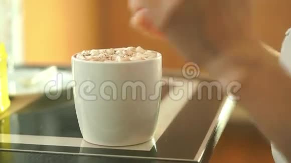一位年轻的美女在大杯里喝可可饮料和棉花糖视频的预览图