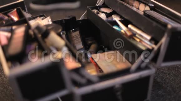 化妆师从她的手提箱里拿出化妆品专业化妆品化妆师在行李箱里多元色视频的预览图
