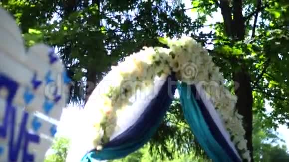 婚礼拱门装饰着布花和字爱婚礼设置视频的预览图