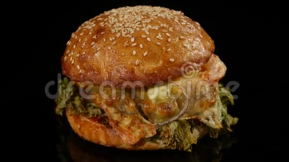 新鲜美味的汉堡在黑色背景上旋转4k无缝可循环射击视频的预览图