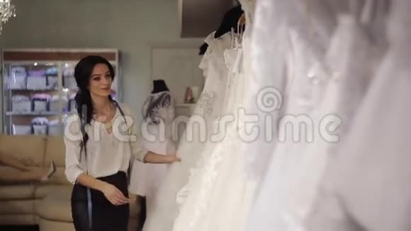 年轻的推销员新娘沙龙为新娘挑选礼服视频的预览图