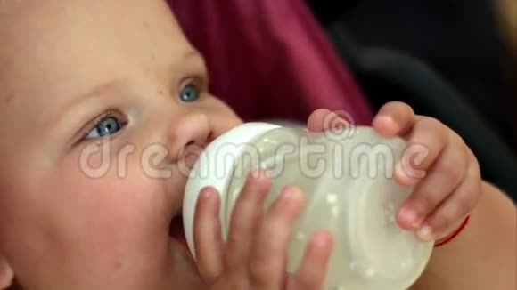 可爱的小女孩蓝眼睛喝牛奶视频的预览图