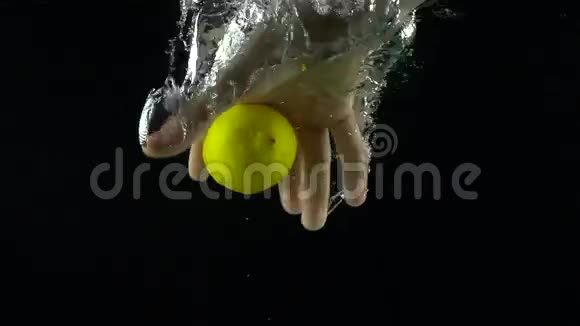 男子手伸出手抓住柠檬漂浮在水中超慢动作镜头视频的预览图