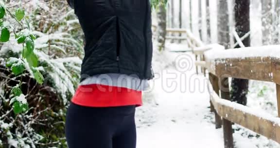 美丽的女人在下雪时锻炼视频的预览图