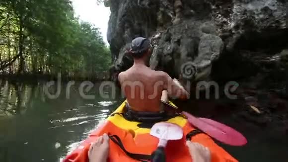 年长的晒黑的人漂浮在独木舟上视频的预览图